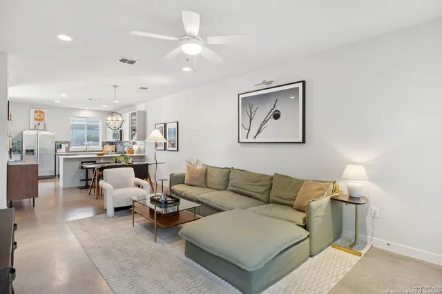 a living room with furniture and view of kitchen