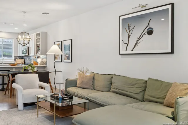 a living room with furniture a rug and wall paintings