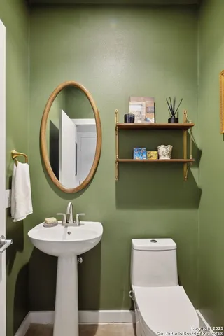 a bathroom with a toilet sink and mirror