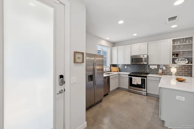 a kitchen with refrigerator and cabinets