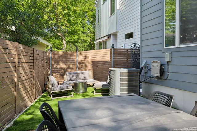 a backyard of a house with barbeque oven and outdoor seating