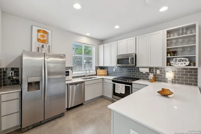a kitchen with granite countertop a sink stainless steel appliances and counter space