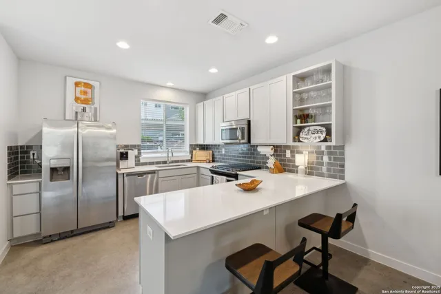 a kitchen with a refrigerator a sink and cabinets