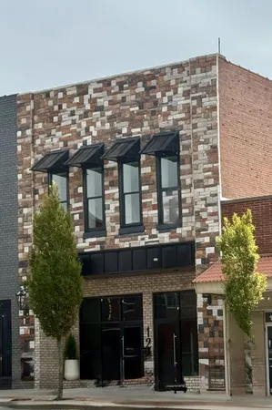 a front view of a building with a garden