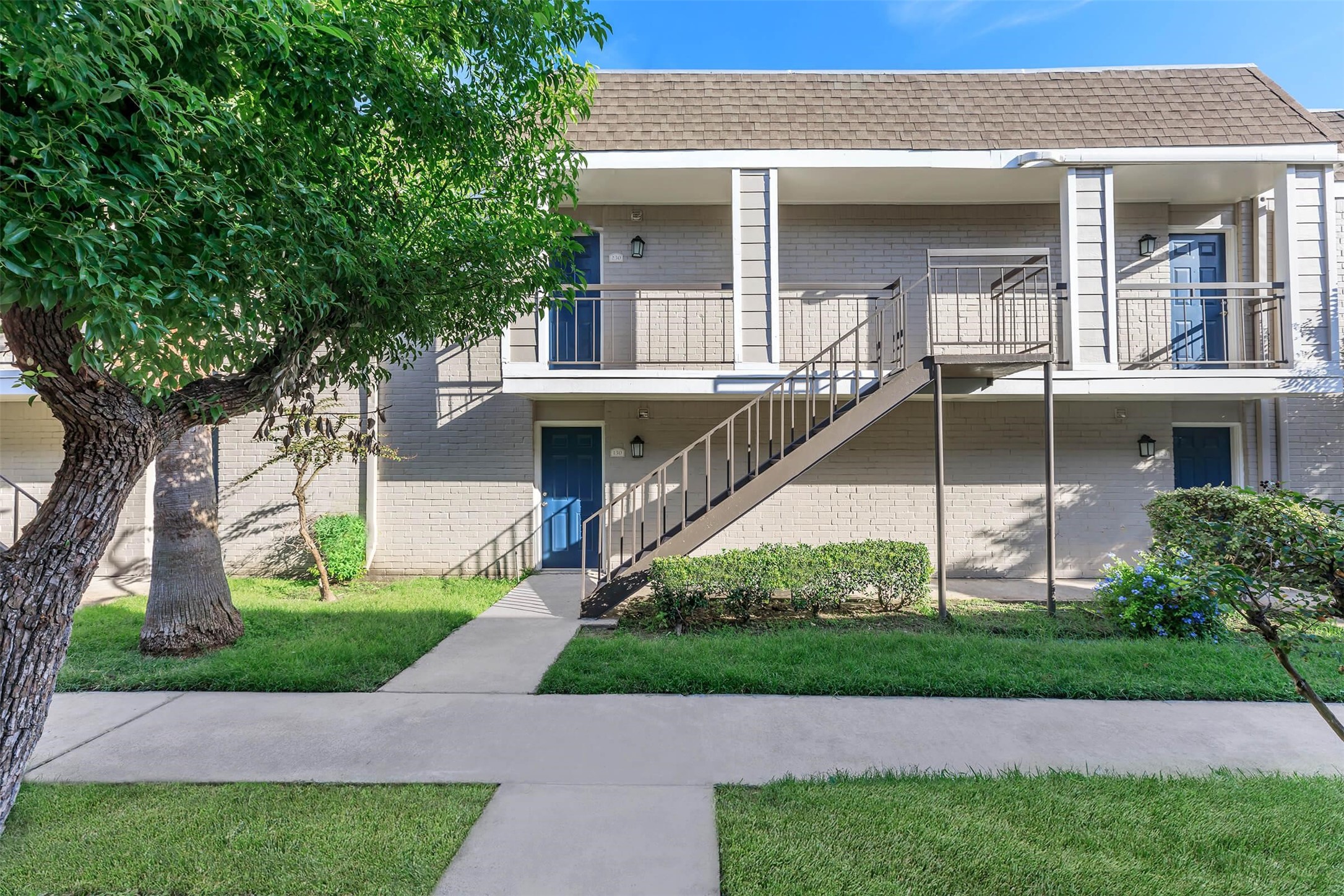 6041 Winsome Lane, Unit 103 Houston, TX 77057 - Photo 13 of 18 a front view of a house with a yard and trees