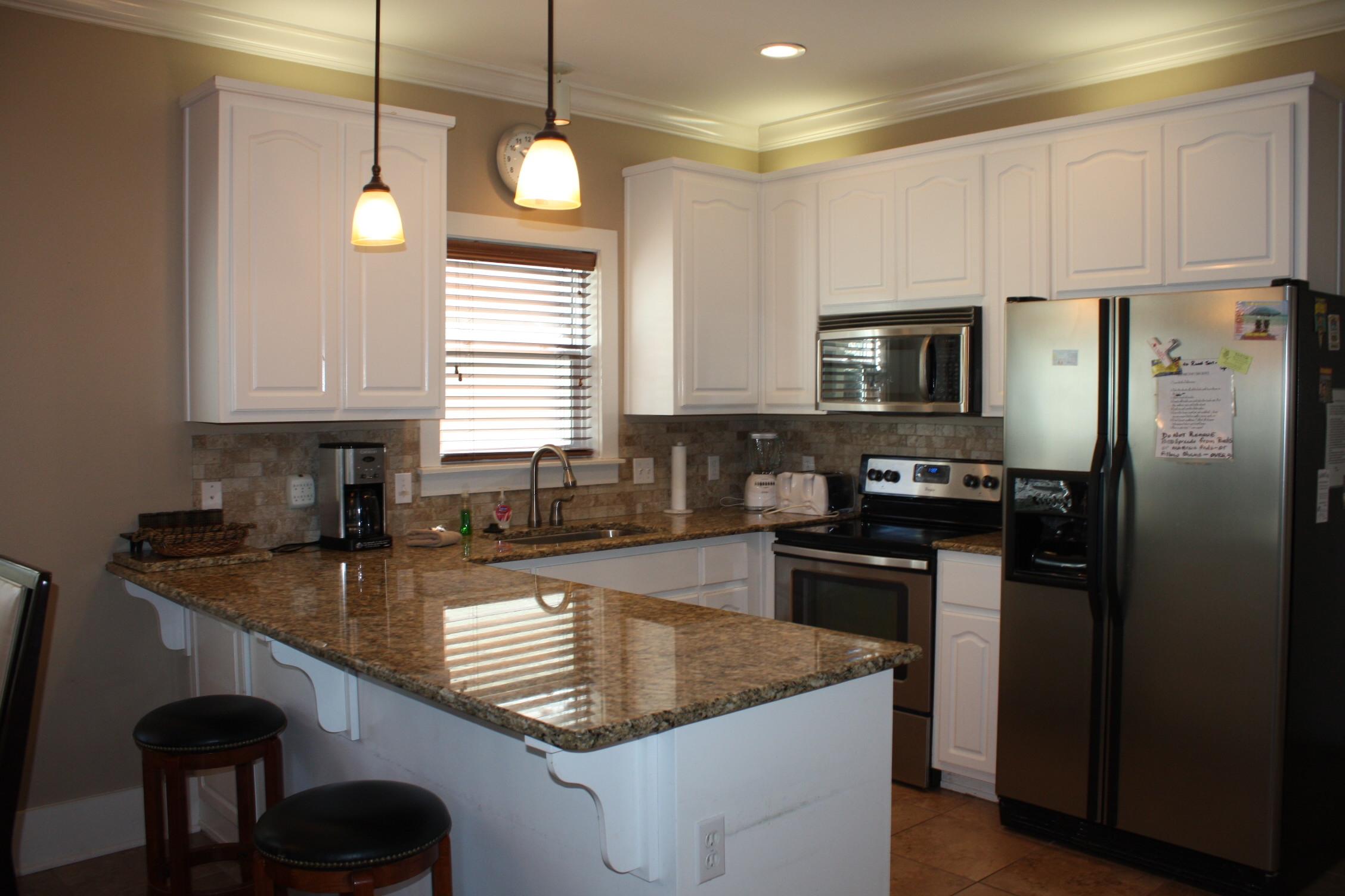 516 Hidden Lake Way Santa Rosa Beach, FL 32459 - Photo 4 of 24 a kitchen with kitchen island granite countertop a sink a counter space appliances and cabinets