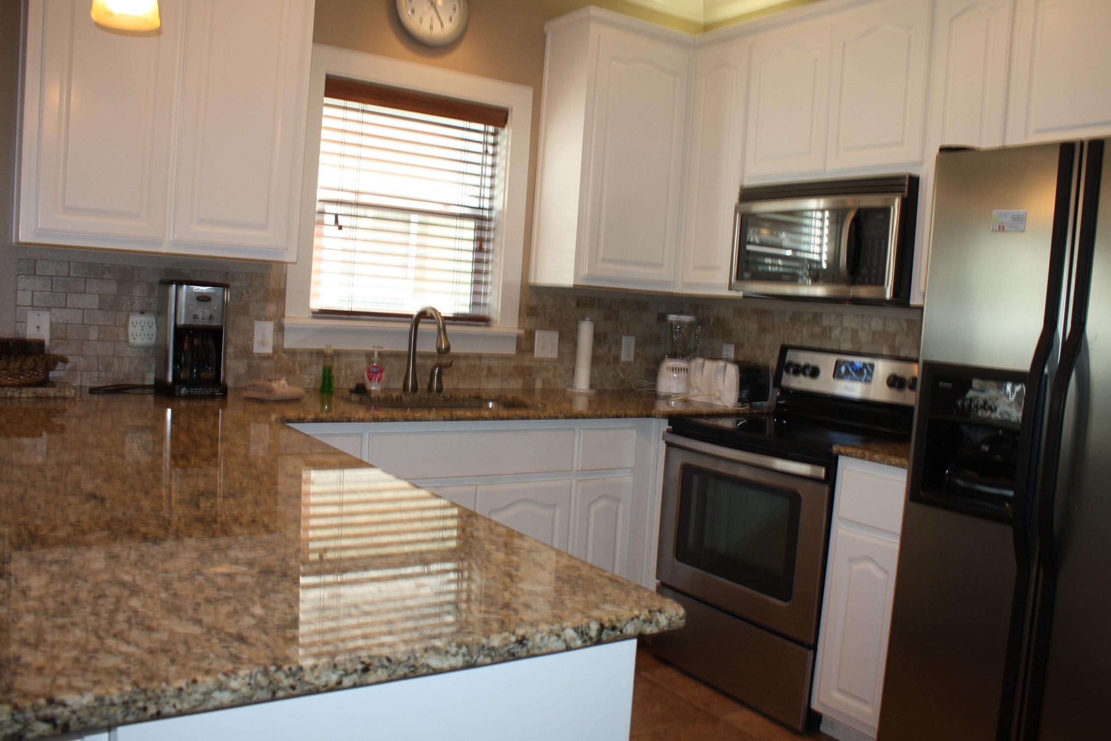 516 Hidden Lake Way Santa Rosa Beach, FL 32459 - Photo 5 of 24 a kitchen with granite countertop stainless steel appliances a stove a sink a refrigerator a counter space and cabinets