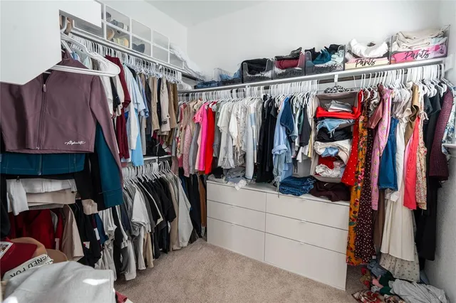 a view of walk in closet with clothes