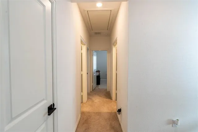 a view of a hallway with a cabinet and a mirror
