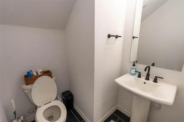 a bathroom with a sink mirror and toilet