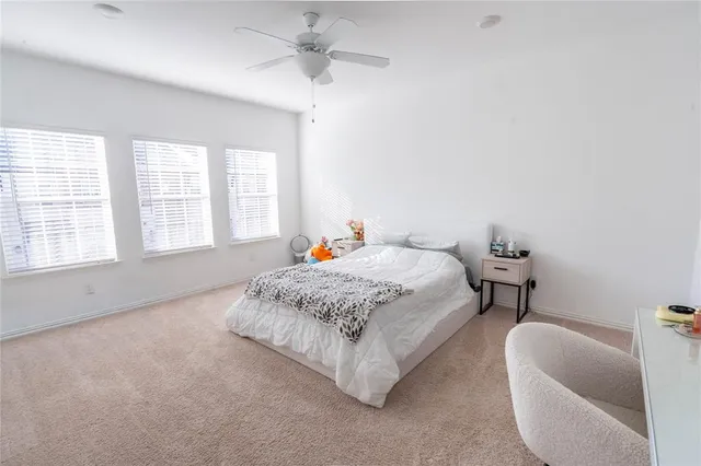 a spacious bedroom with a bed a couch and a chandelier