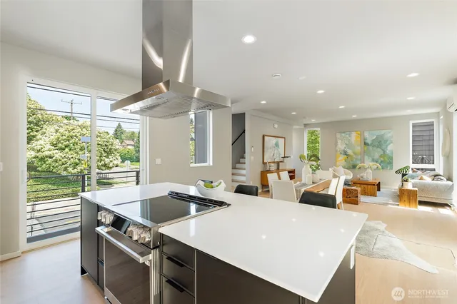 a large kitchen with kitchen island a large window in it