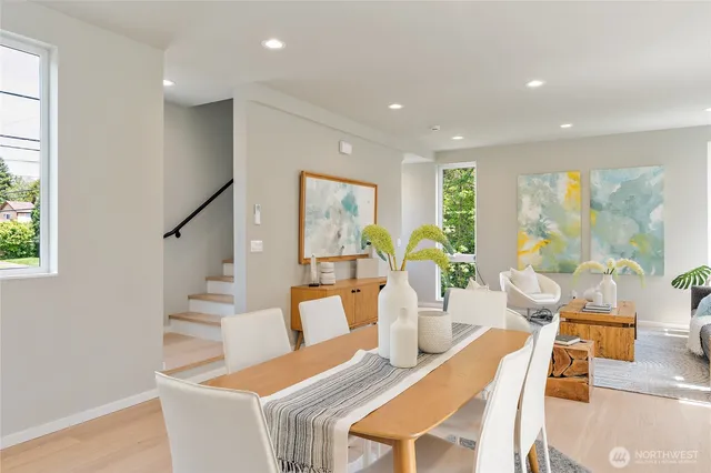 a view of a dining room with furniture a potted plant and wooden floor