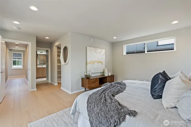 a bedroom with a large bed and wooden floor