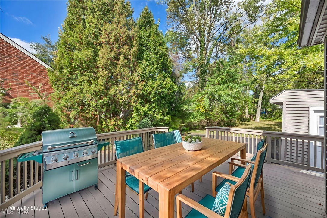 5103 Eastover Road Cleveland, OH 44124 - Photo 29 of 34 Wooden deck with view of scattered trees, grilling area, outdoor dining area, and a storage unit