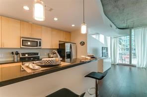 5925 Almeda Road, Unit 10808 Houston, TX 77004 - Photo 3 of 9 a kitchen with stainless steel appliances a sink a stove a microwave a refrigerator and cabinets