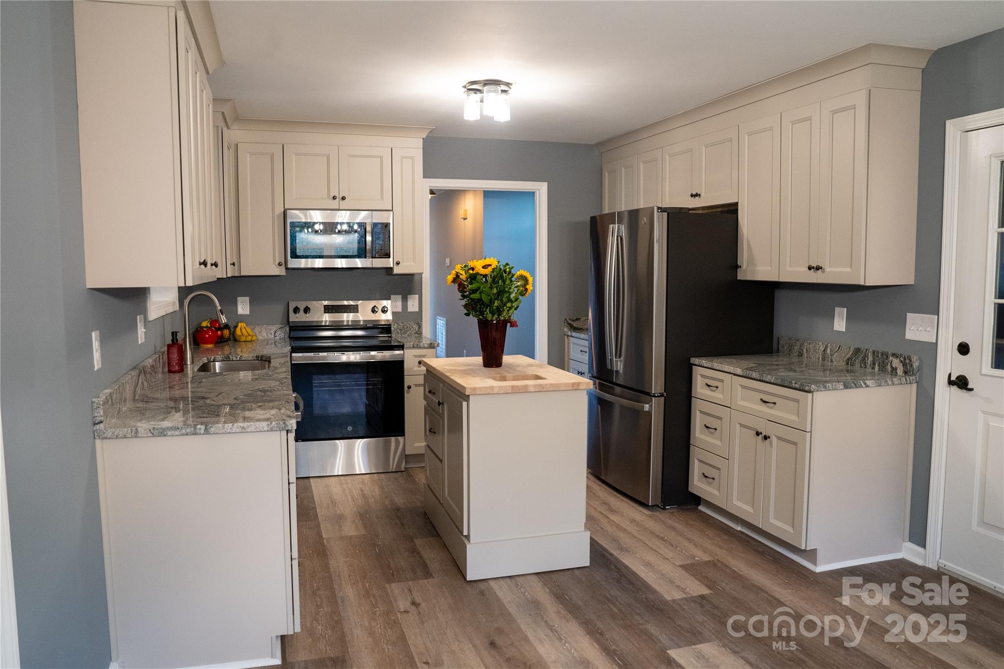 44585 Baldwin Road New London, NC 28127 - Photo 11 of 47 a kitchen with a refrigerator a stove top oven a sink and dishwasher with wooden floor