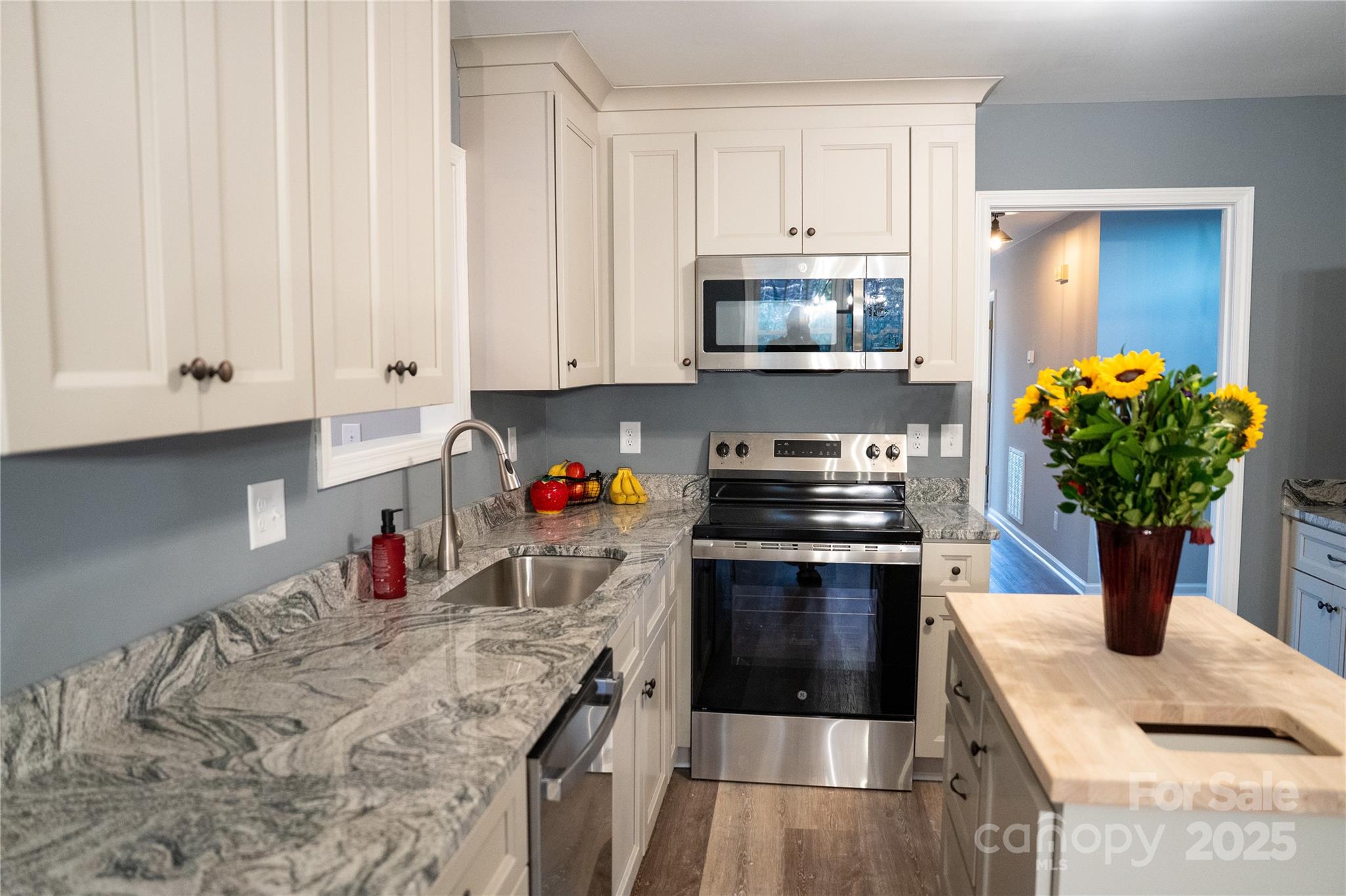 44585 Baldwin Road New London, NC 28127 - Photo 12 of 47 a kitchen with stainless steel appliances granite countertop a stove a sink and white cabinets