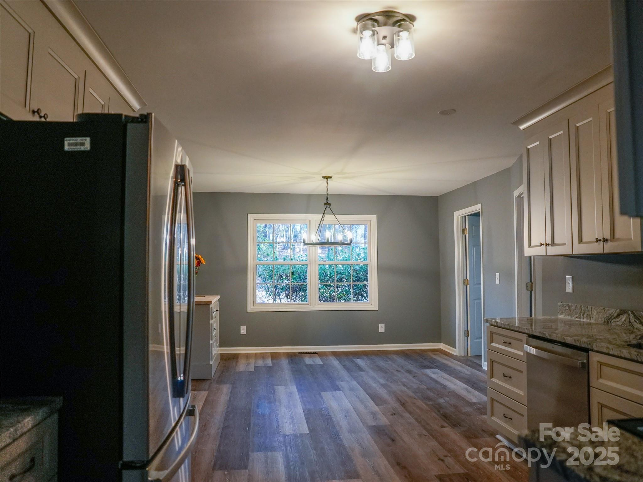 44585 Baldwin Road New London, NC 28127 - Photo 15 of 47 a kitchen with stainless steel appliances granite countertop a refrigerator a sink dishwasher a stove and a dining table with wooden floor