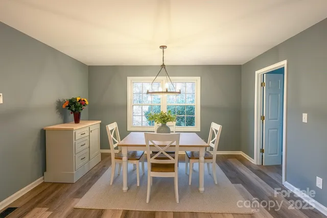 a dining room with furniture a chandelier and wooden floor