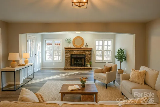 a living room with furniture a fireplace and a large window