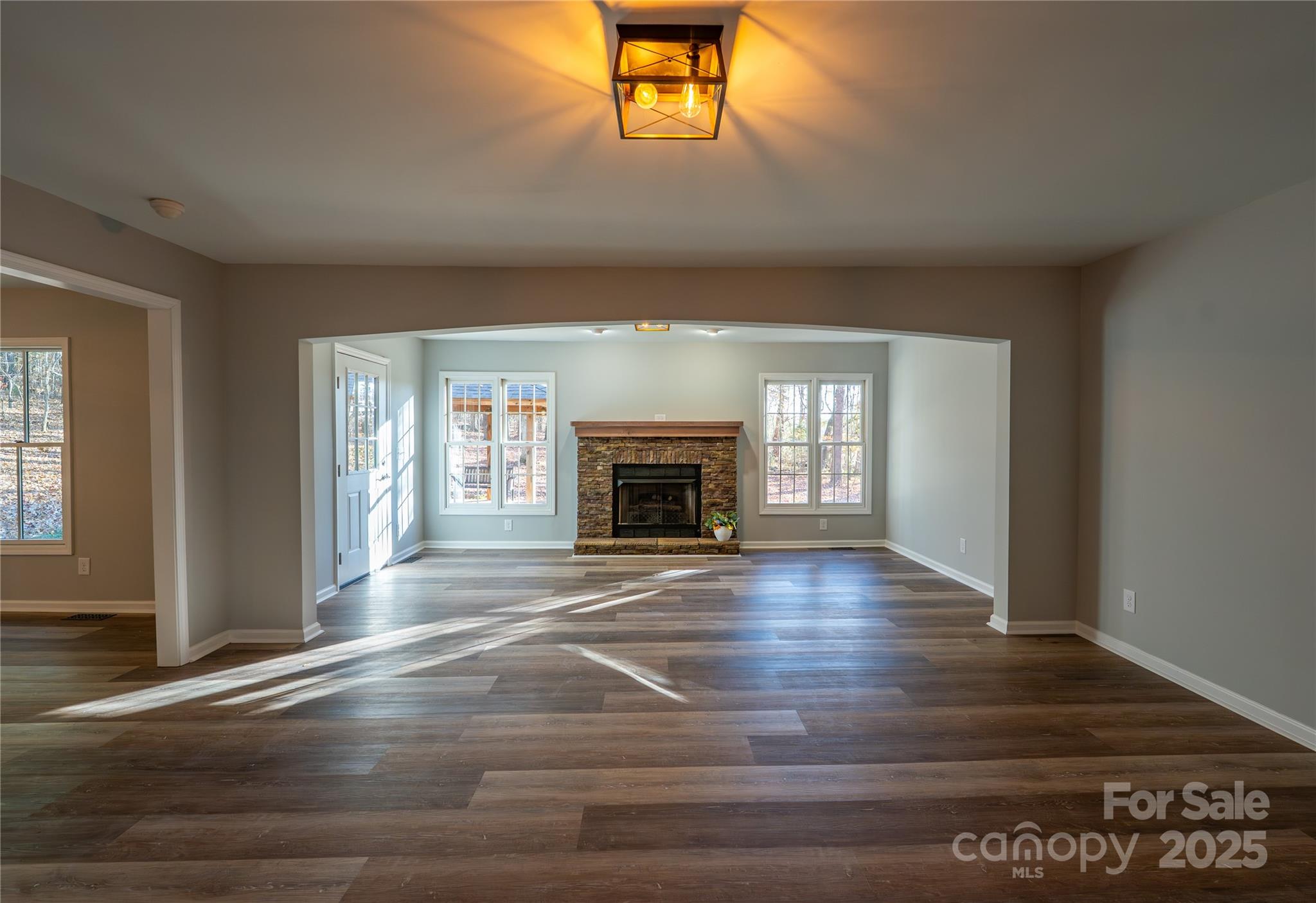 44585 Baldwin Road New London, NC 28127 - Photo 6 of 47 an empty room with wooden floor and fireplace