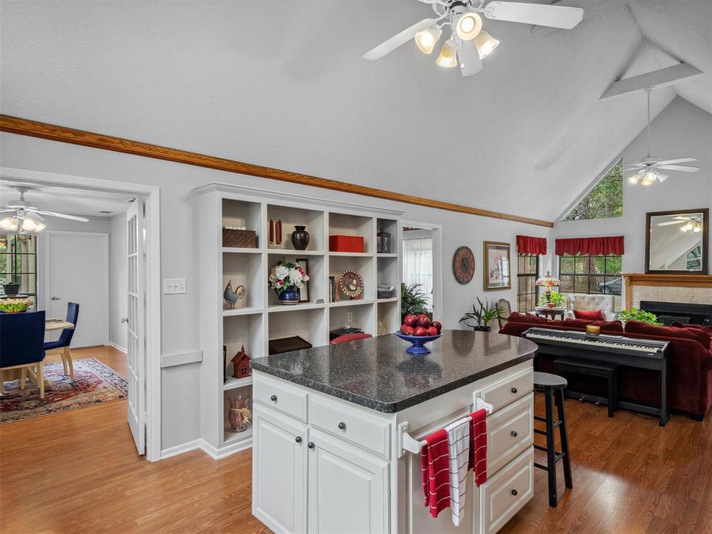 299 Lamplight Path Holly Lake Ranch, TX 75765 - Photo 11 of 40 a open kitchen with stainless steel appliances granite countertop a dining table and chairs with wooden floor