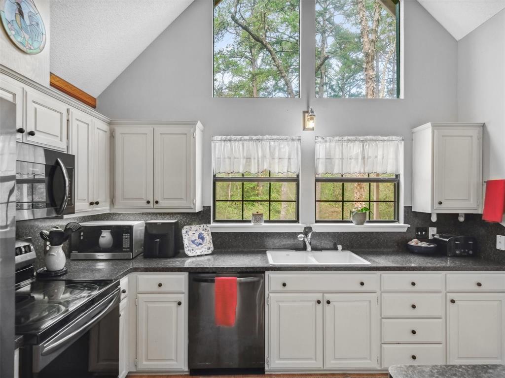 299 Lamplight Path Holly Lake Ranch, TX 75765 - Photo 14 of 40 a kitchen with granite countertop a sink a stove and cabinets