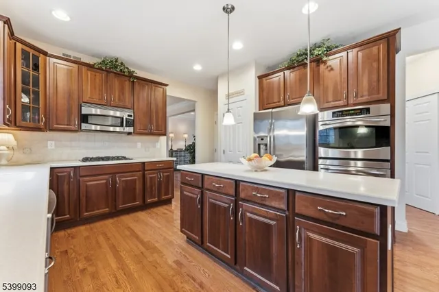 a kitchen with stainless steel appliances granite countertop wooden cabinets a stove top oven a sink and dishwasher