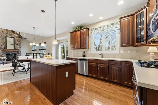 a kitchen with kitchen island granite countertop a sink counter top space appliances and cabinets