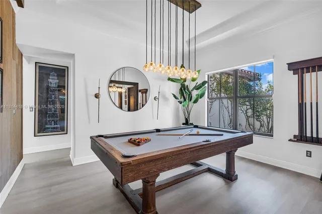 a room with pool table and windows