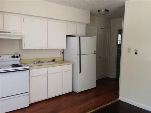 a kitchen with a refrigerator sink and cabinets