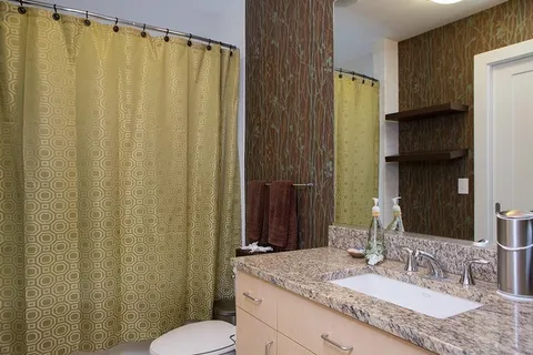 a bathroom with a granite countertop sink and a mirror