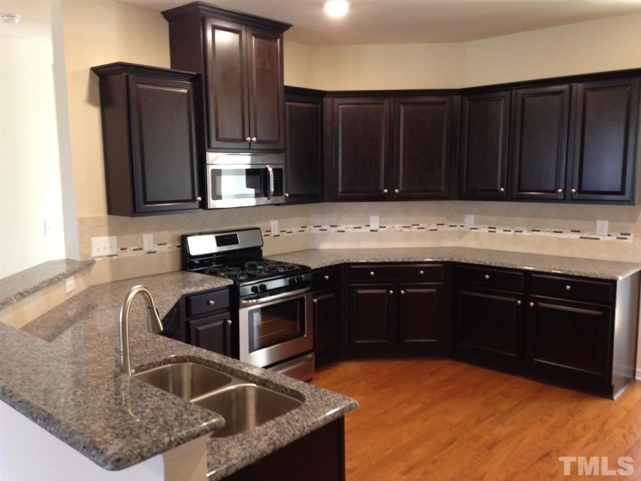 632 Edgewater Ridge Court Apex, NC 27523 - Photo 19 of 21 a kitchen with a sink stove and microwave