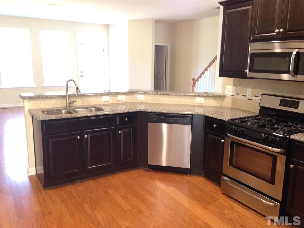 632 Edgewater Ridge Court Apex, NC 27523 - Photo 20 of 21 a kitchen with stainless steel appliances granite countertop a stove a sink and a microwave