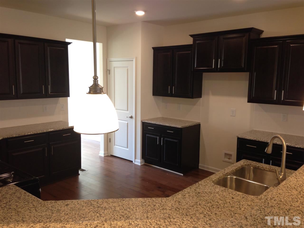 632 Edgewater Ridge Court Apex, NC 27523 - Photo 3 of 21 a kitchen with a sink a stove and microwave