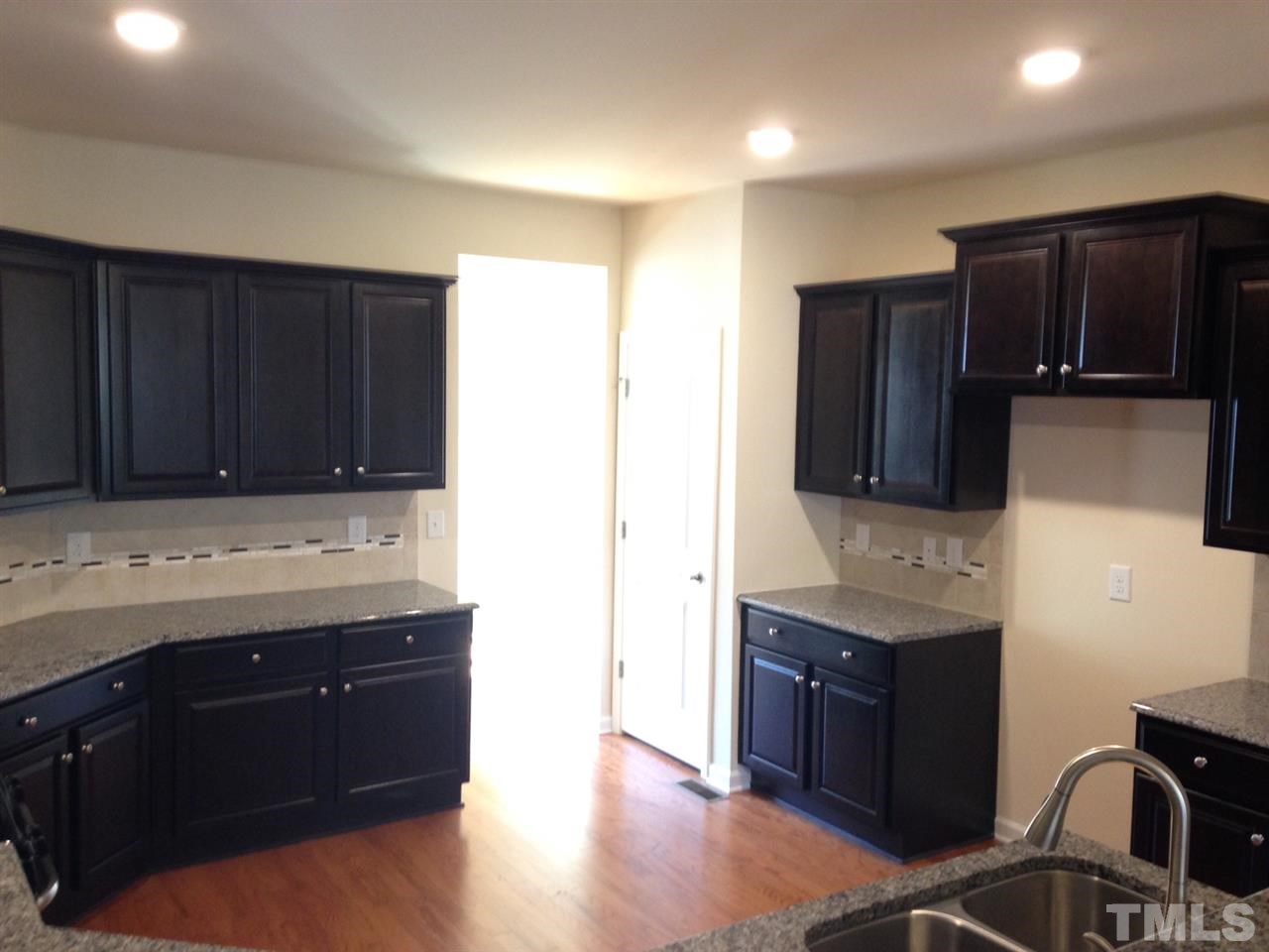 632 Edgewater Ridge Court Apex, NC 27523 - Photo 21 of 21 a kitchen with granite countertop stainless steel appliances and wooden cabinets