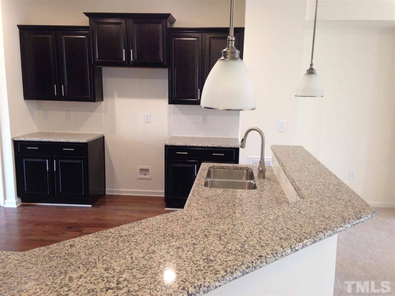 632 Edgewater Ridge Court Apex, NC 27523 - Photo 5 of 21 a kitchen with granite countertop a sink and a stove top oven