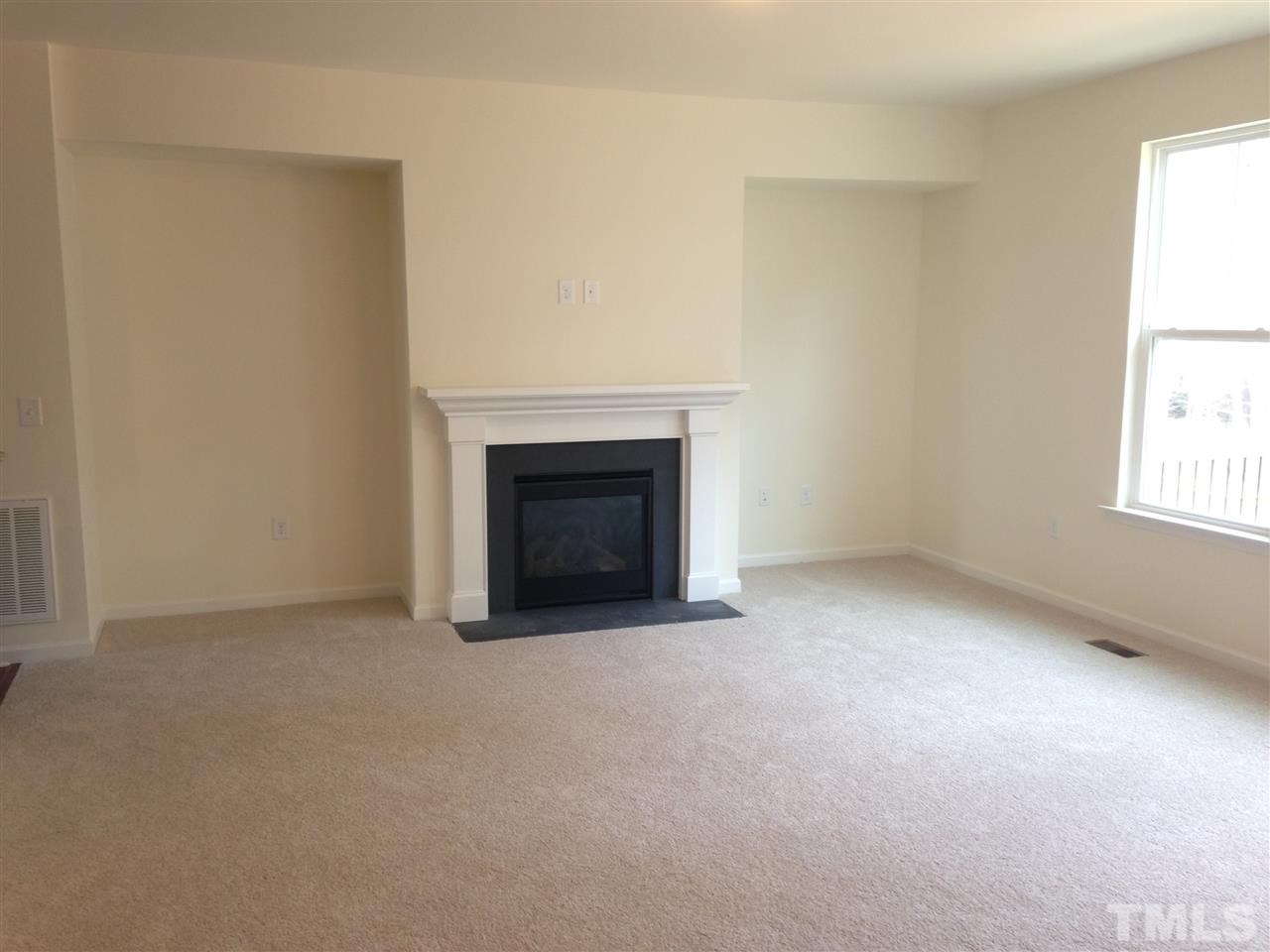 632 Edgewater Ridge Court Apex, NC 27523 - Photo 6 of 21 an empty room with a fireplace and window