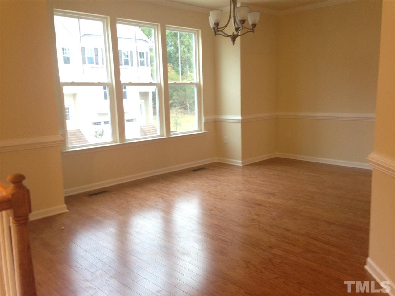 632 Edgewater Ridge Court Apex, NC 27523 - Photo 7 of 21 an empty room with wooden floor and windows