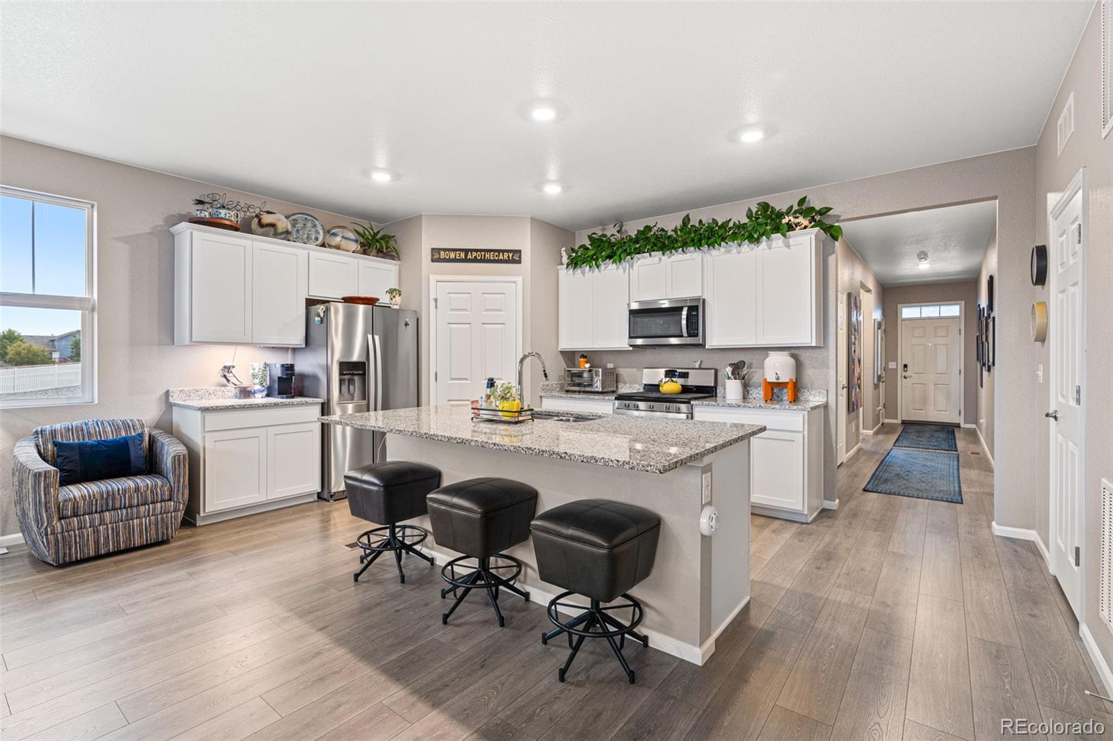 10054 Carefree Street Firestone, CO 80504 - Photo 17 of 50 a kitchen with granite countertop white cabinets and refrigerator
