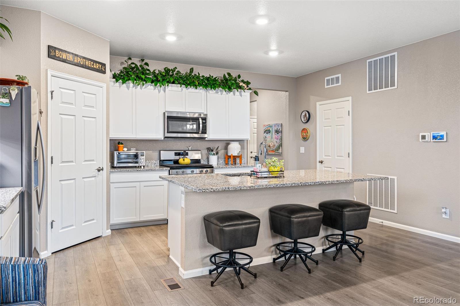 10054 Carefree Street Firestone, CO 80504 - Photo 19 of 50 a kitchen with a table chairs refrigerator and microwave
