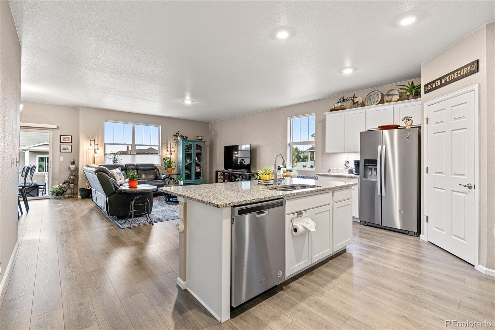 10054 Carefree Street Firestone, CO 80504 - Photo 20 of 50 a kitchen with stainless steel appliances granite countertop a refrigerator a stove a sink dishwasher and a refrigerator with wooden floor