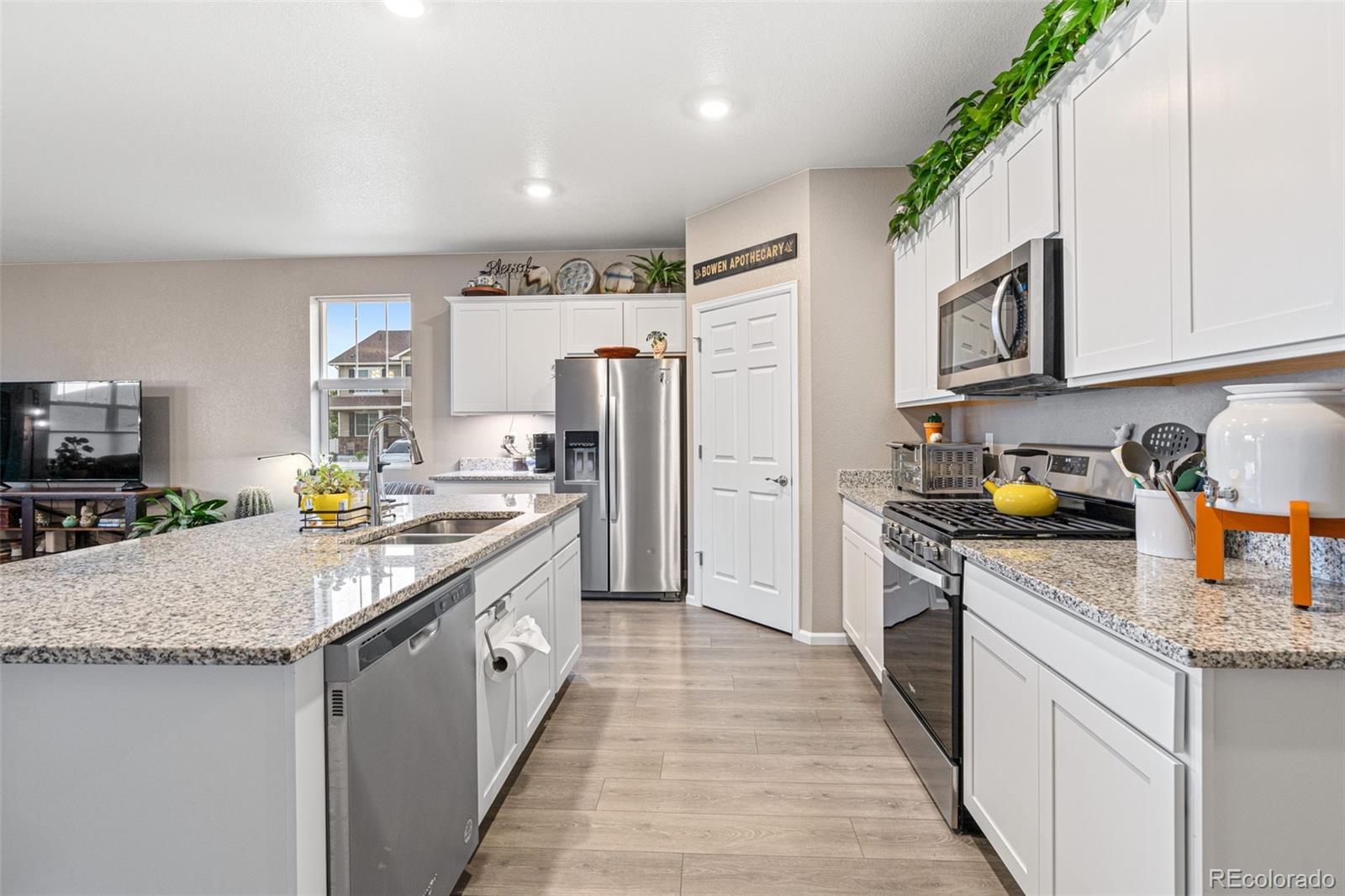 10054 Carefree Street Firestone, CO 80504 - Photo 21 of 50 a kitchen with stainless steel appliances granite countertop a refrigerator a stove and a sink