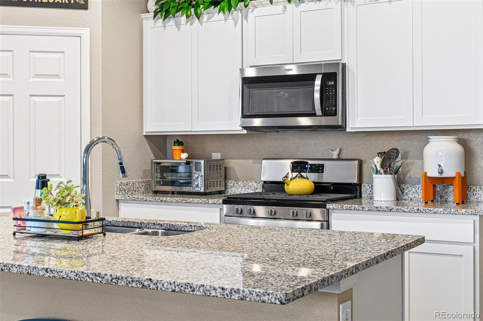 10054 Carefree Street Firestone, CO 80504 - Photo 22 of 50 a kitchen with stainless steel appliances granite countertop a sink a stove and a microwave
