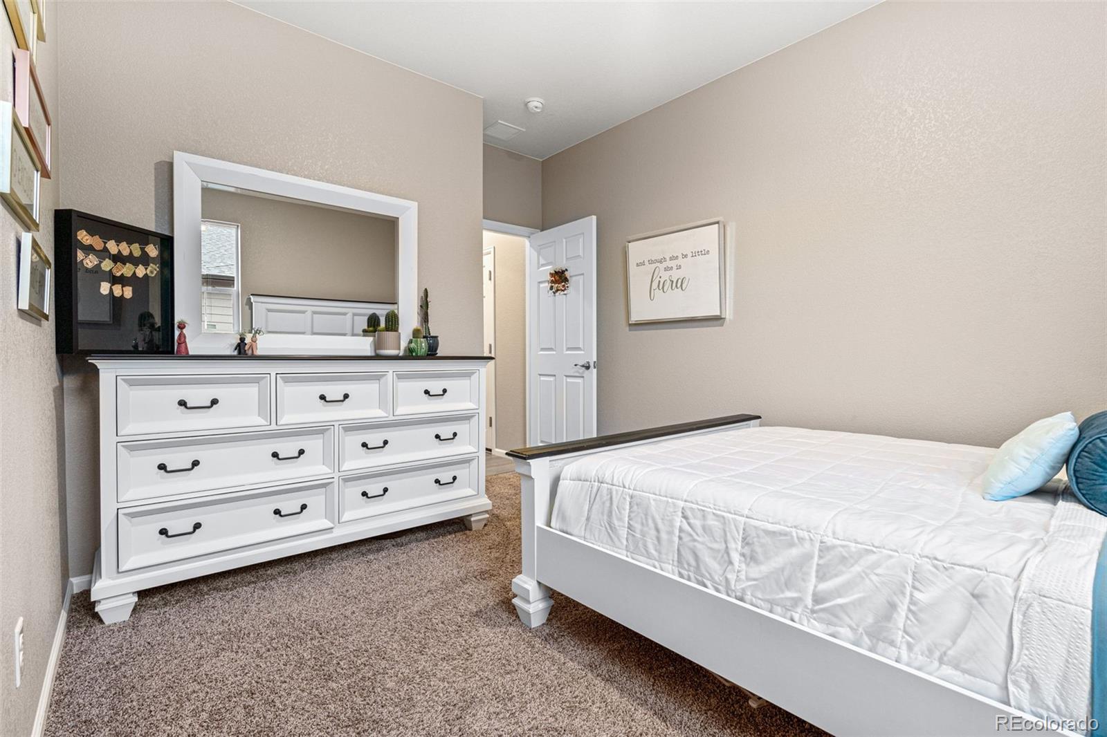 10054 Carefree Street Firestone, CO 80504 - Photo 35 of 50 a bedroom with a bed and a mirror on dresser