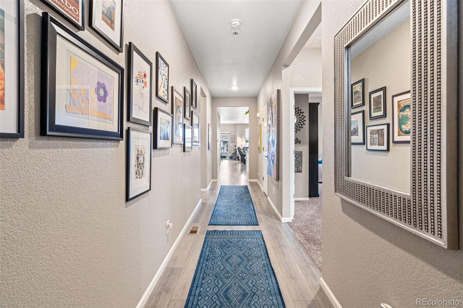 10054 Carefree Street Firestone, CO 80504 - Photo 8 of 50 a view of a hallway with paintings on the wall