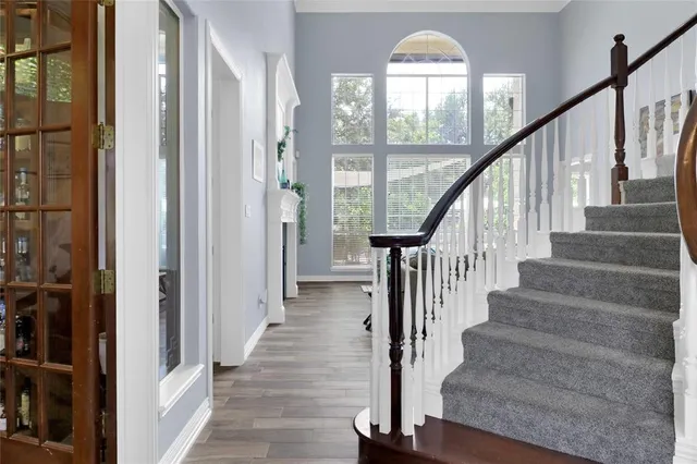 a view of staircase with wooden floor and a large window