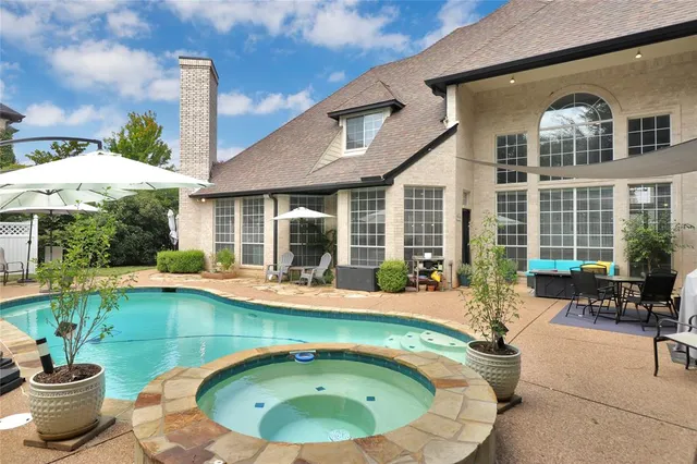 a view of a swimming pool with lawn chairs under an umbrella