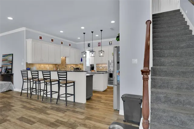 a kitchen with stainless steel appliances granite countertop a refrigerator a stove top oven and white cabinets